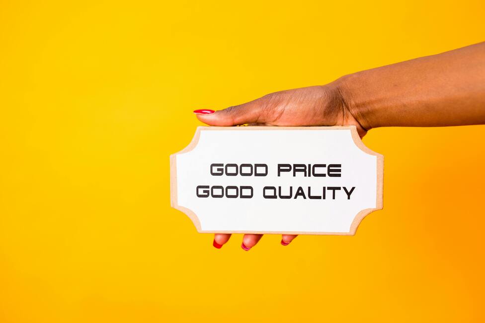 Hand holding a sign that reads Good Price, Good Quality